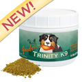 A white plastic jar of Garden Trinity K9 dog supplement with a green label featuring a Bernese mountain dog illustration, shown with a small pile of the brownish-green powder in front on a white background. A yellow diagonal banner with the word 'NEW!' is visible in the top left corner.