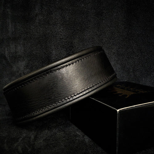 Black leather belt on a dark textured surface